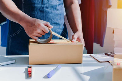 Man taping a box shut representing Curative's Kitting Services