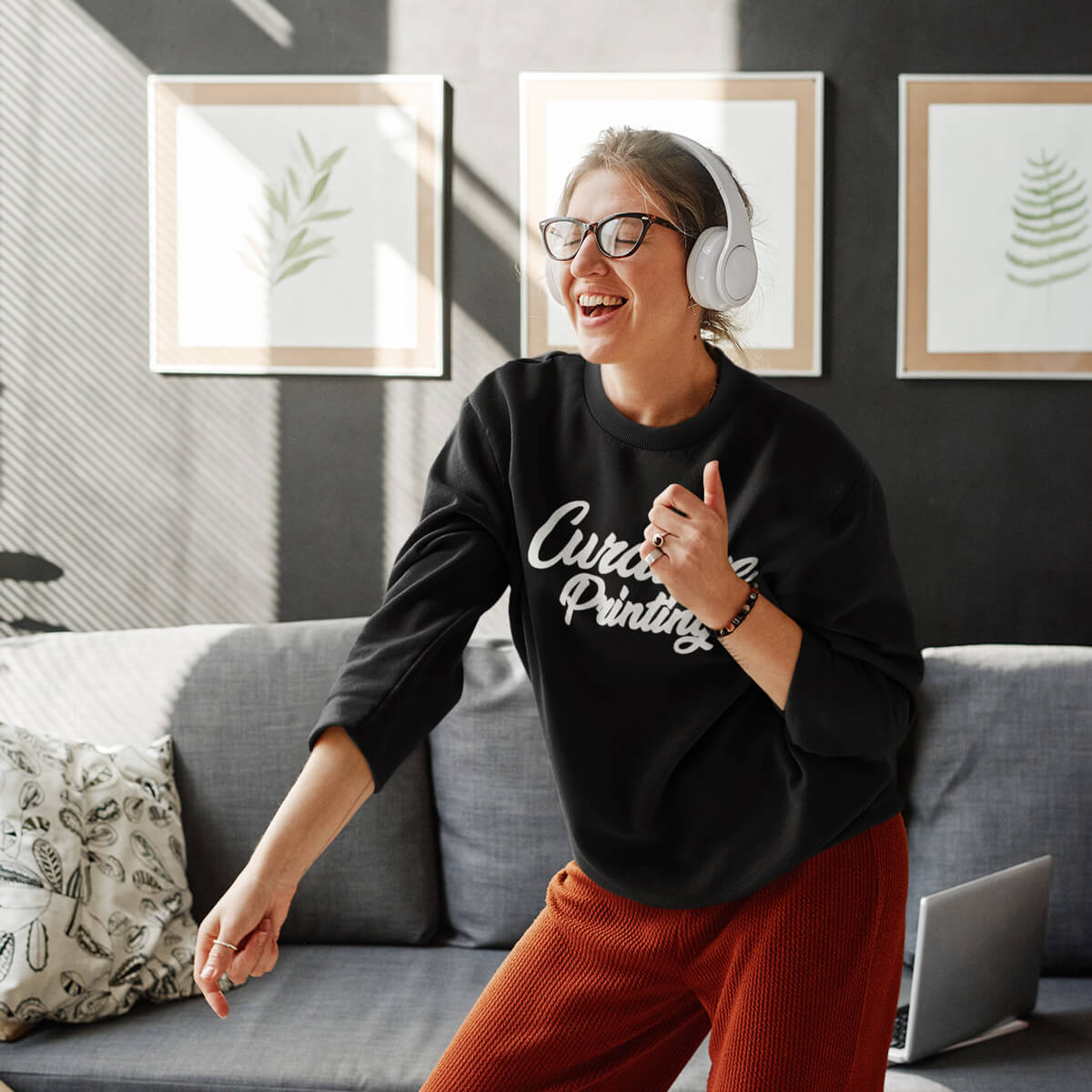 Woman wearing black Curative Printing crewneck sweatshirt while listening to music