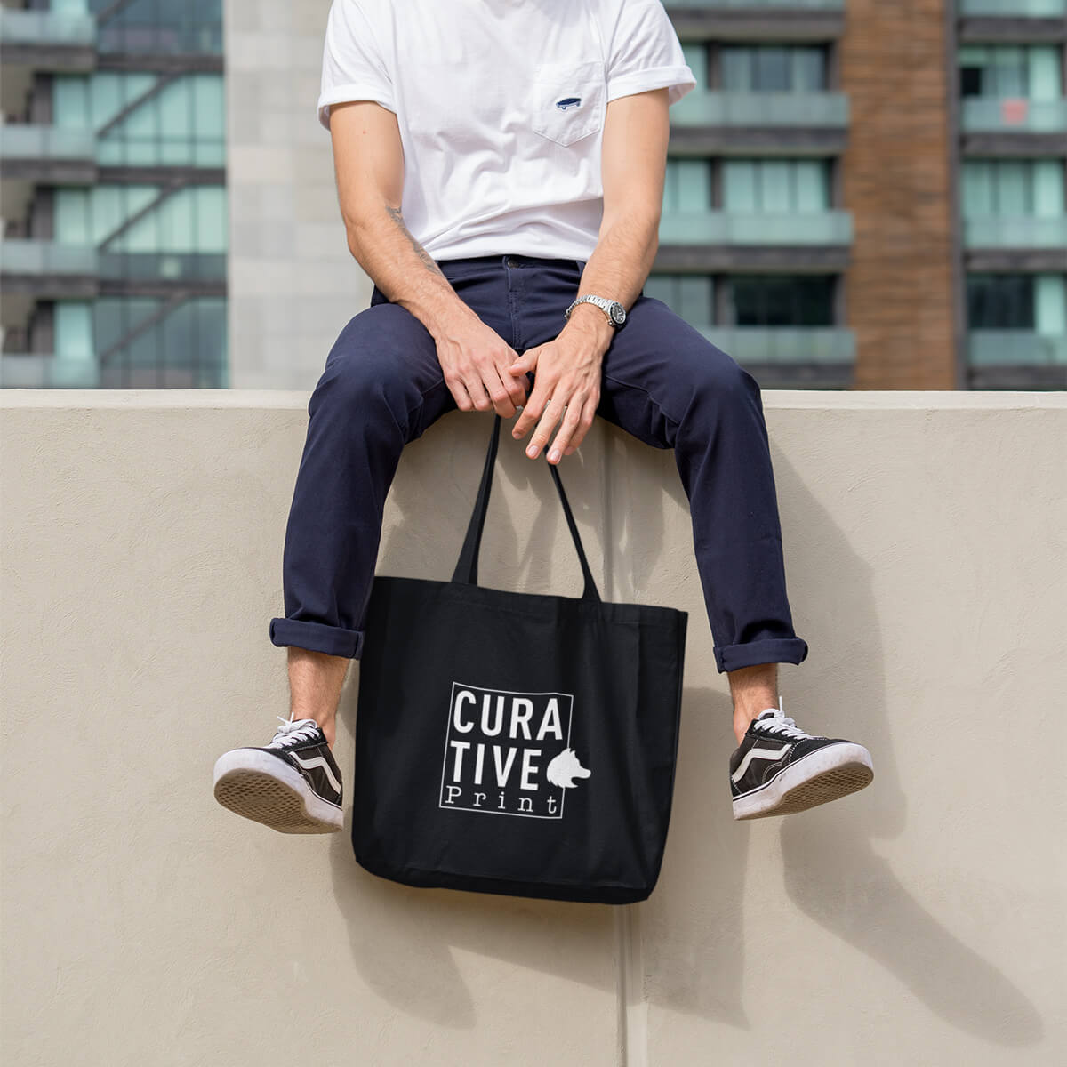 Man holding black with white imprint custom promotional tote bags by curative printing