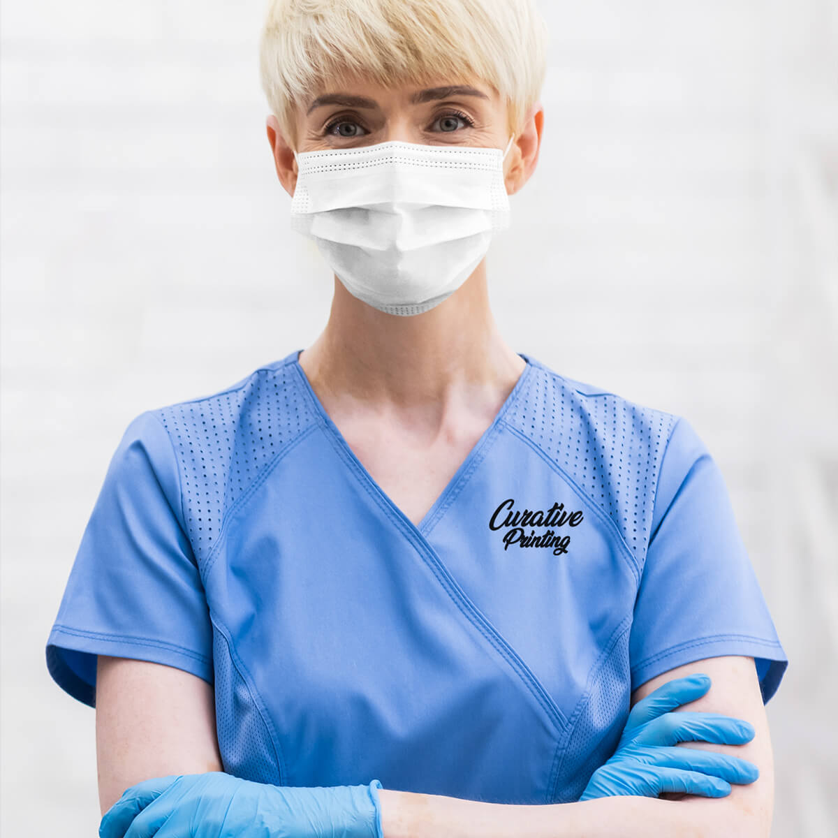 Female medical professional in blue custom branded scrub apparel promotional wellness & safety by curative printing