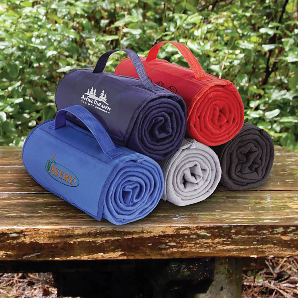 Outdoor stack of custom promotional roll-up blankets by curative printing