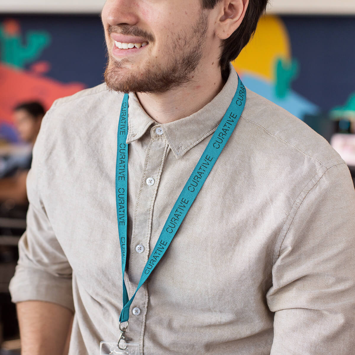 Man wearing turquoise with black imprint lanyard promotional wellness & safety by curative printing