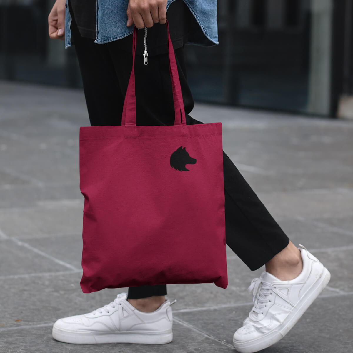 Woman carrying red with black imprint custom promotional tote bags by curative printing