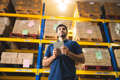 Man in a warehouse checking stock of products representing Curative's Stock Inventory Control Services