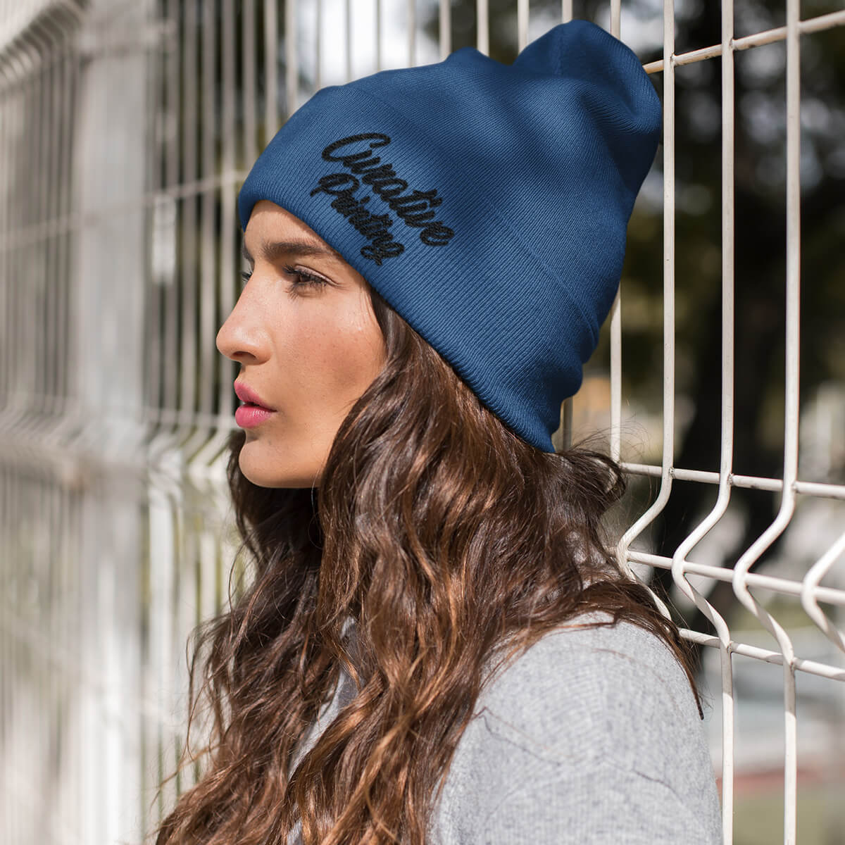 Woman wearing navy beanie with Curative Printing logo.