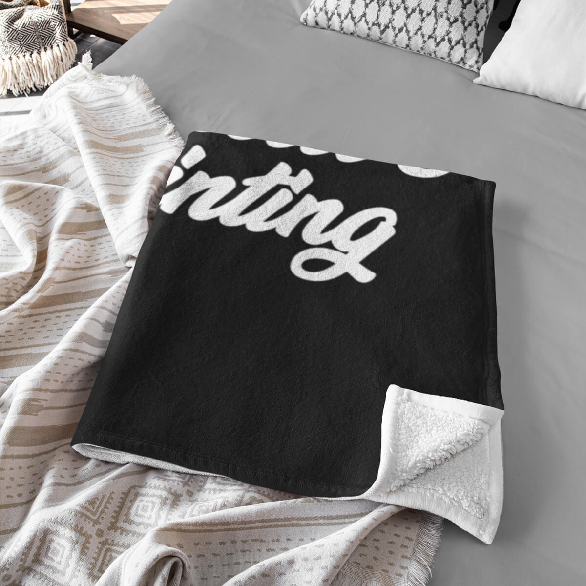Folded on bed black and white custom promotional throw blankets by curative printing
