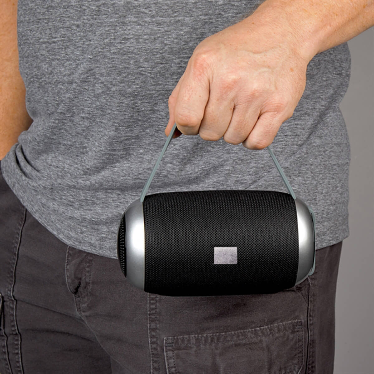 Man holding black portable speaker promotional technology by curative printing