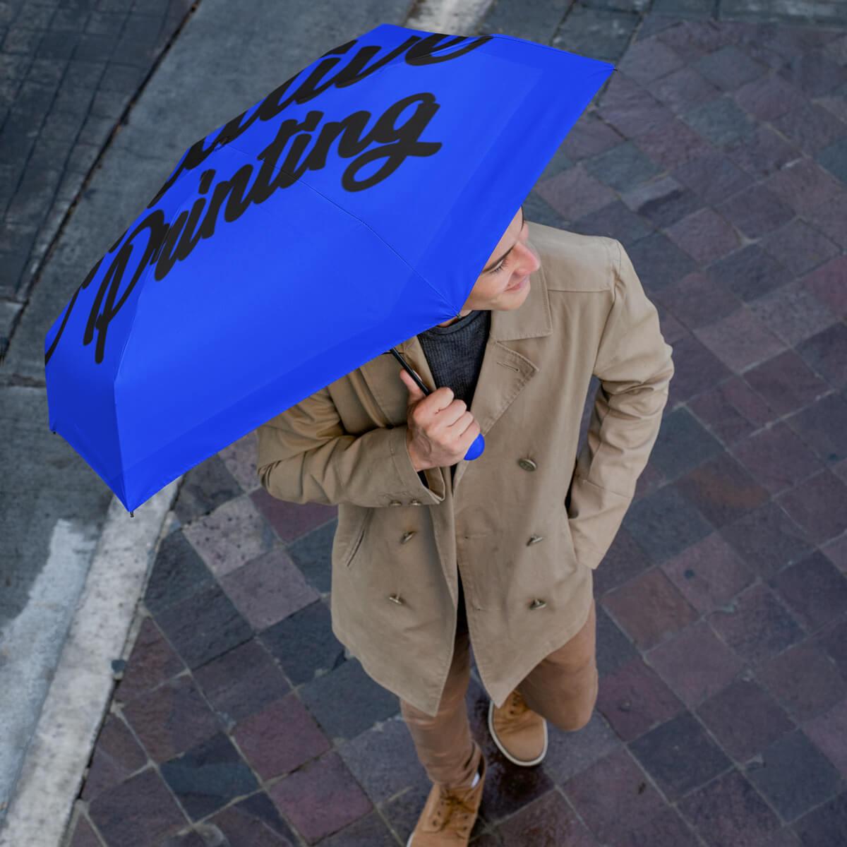 Man on street holding blue folding umbrella promotional umbrellas by curative printing