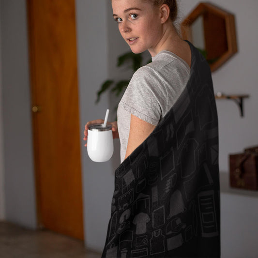 Woman wrapped in a black custom promotional throw blankets by curative printing