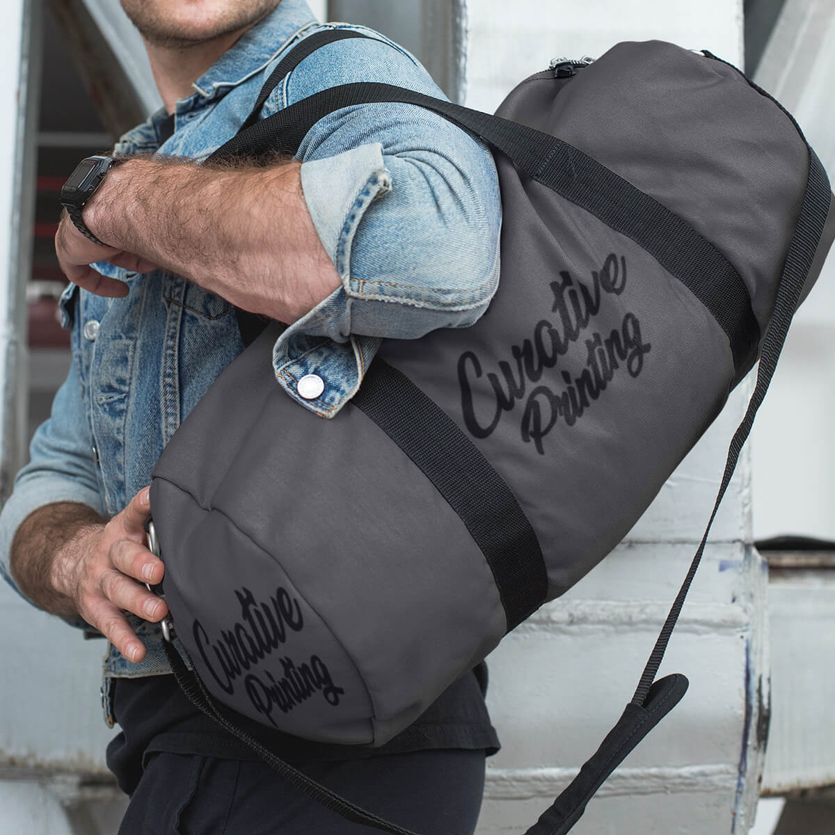 Trendy man carrying grey custom promotional duffle bags by curative printing