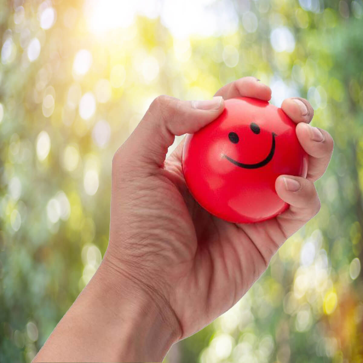 Hand holding red smiley stress ball promotional wellness & safety by curative printing