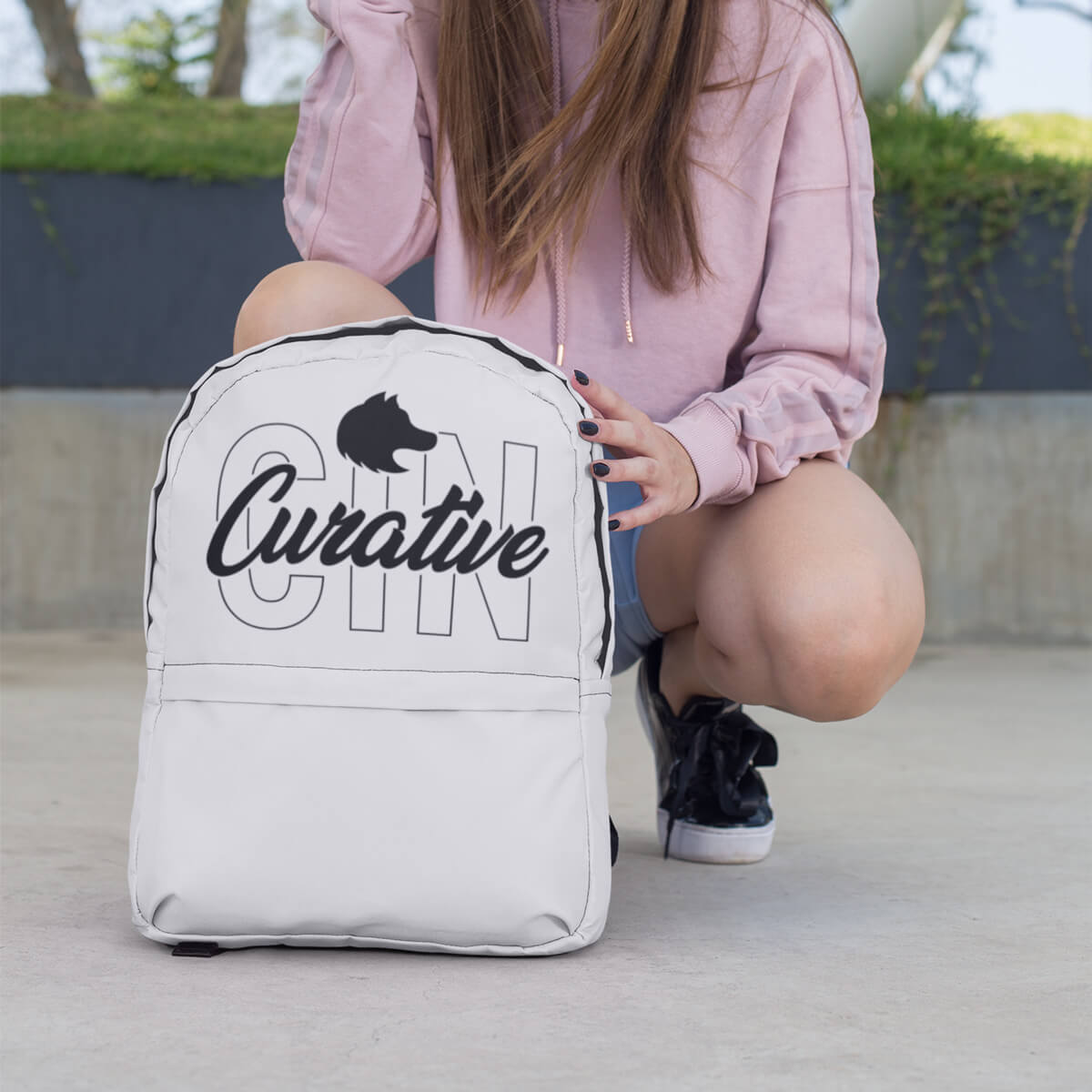 Girl kneeling with custom promotional backpack bag by curative printing