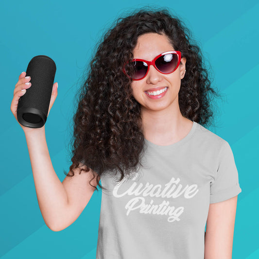 Lady smiling holding black portable speaker promotional technology by curative printing