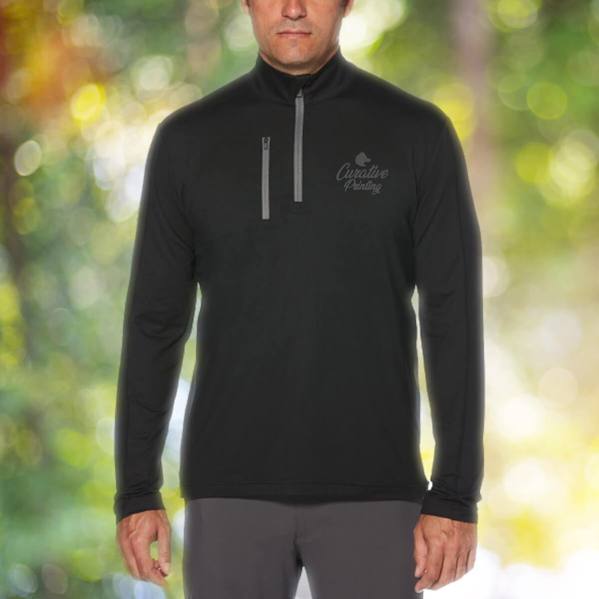 Man in the outdoors wearing black quarter zip sweatshirt apparel with black curative printing logo imprint