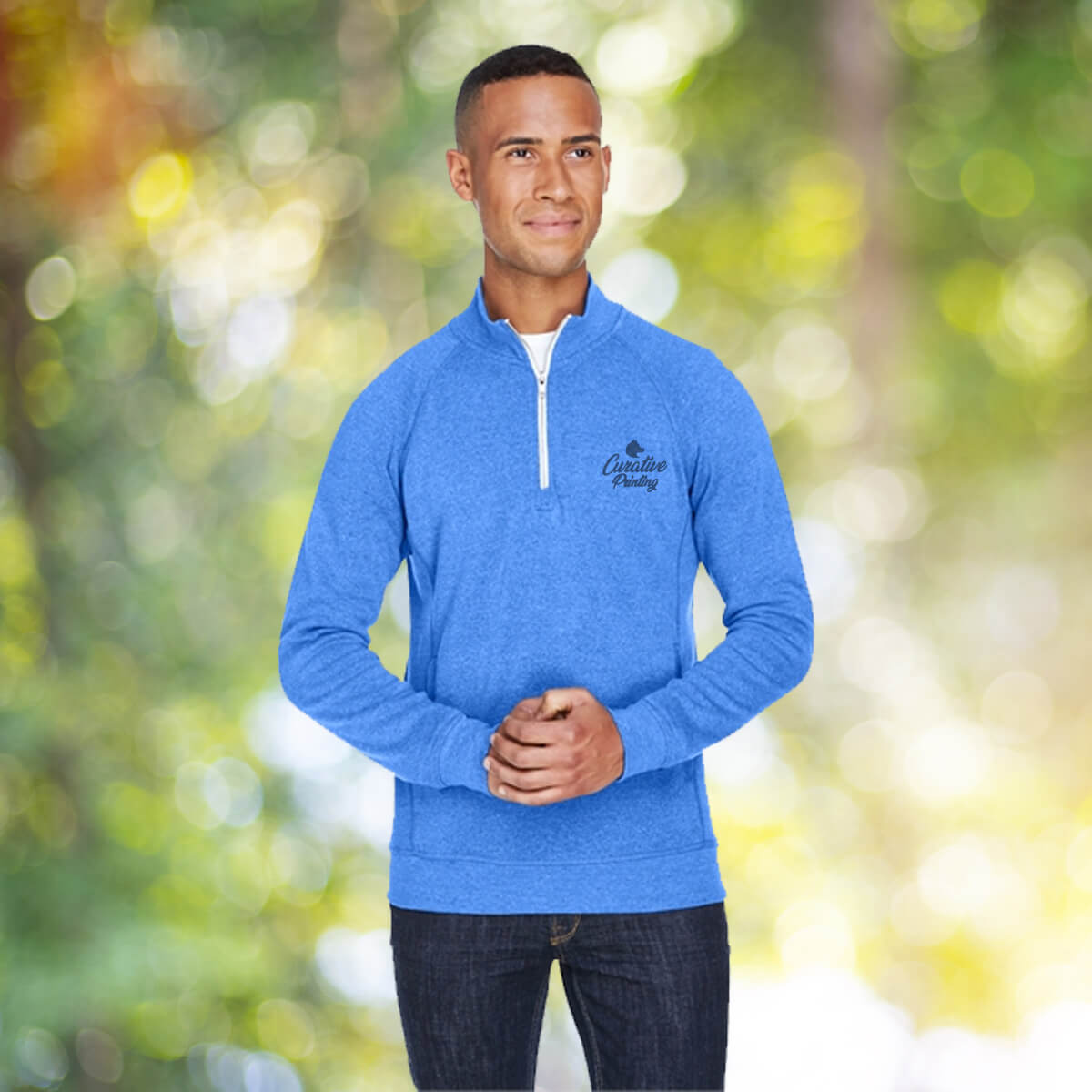 Man in the outdoors wearing blue quarter zip sweatshirt apparel with black curative printing logo imprint