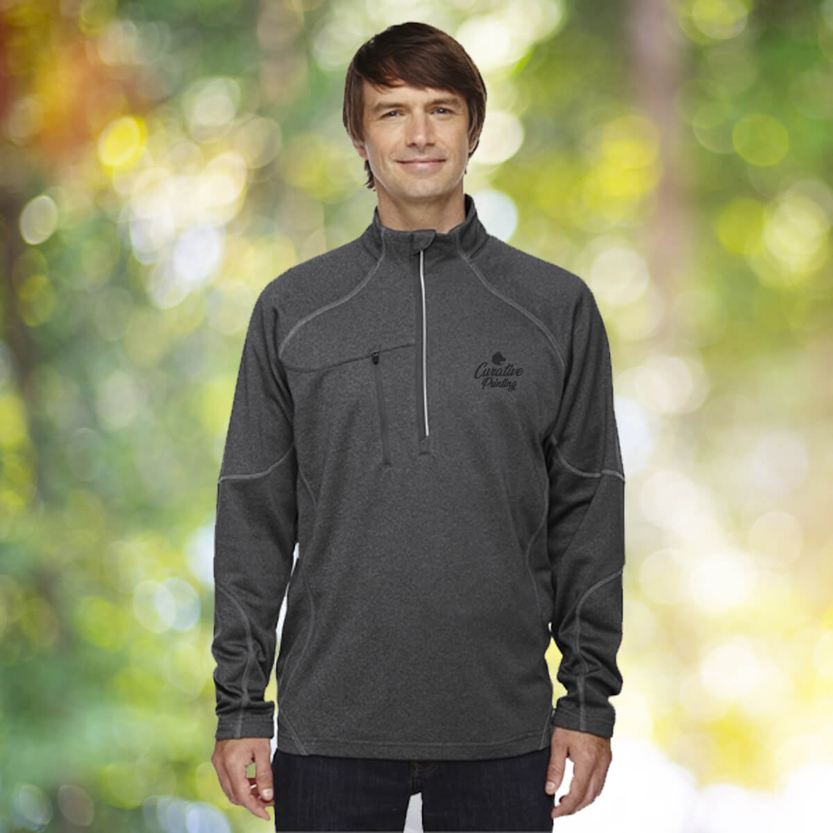 Man in the outdoors wearing grey quarter zip sweatshirt apparel with black curative printing logo imprint