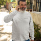 Bearded man walks outside wearing a white long sleeve t-shirt tee with black curative printing logo imprint