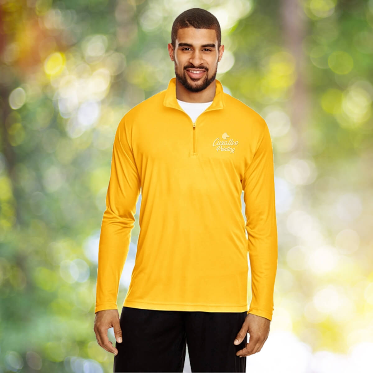 Man in the outdoors wearing yellow quarter zip sweatshirt apparel with white curative printing logo imprint