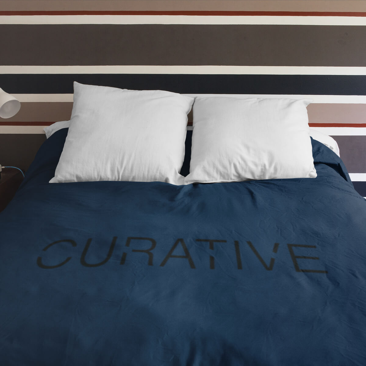 Bed covered by navy with black imprint custom promotional fleece blankets by curative printing