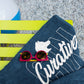 Yellow table holding navy with white imprint beach towel promotional towels by curative printing