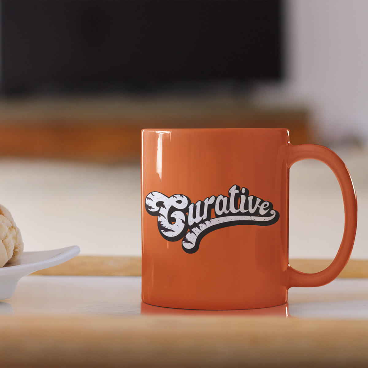 Table holding orange ceramic mugs custom promotional drinkware by curative printing