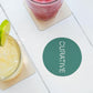 Table top with round green coaster custom promotional drinkware by curative printing