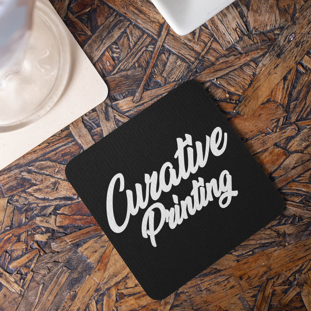 Table top with square black coaster custom promotional drinkware by curative printing