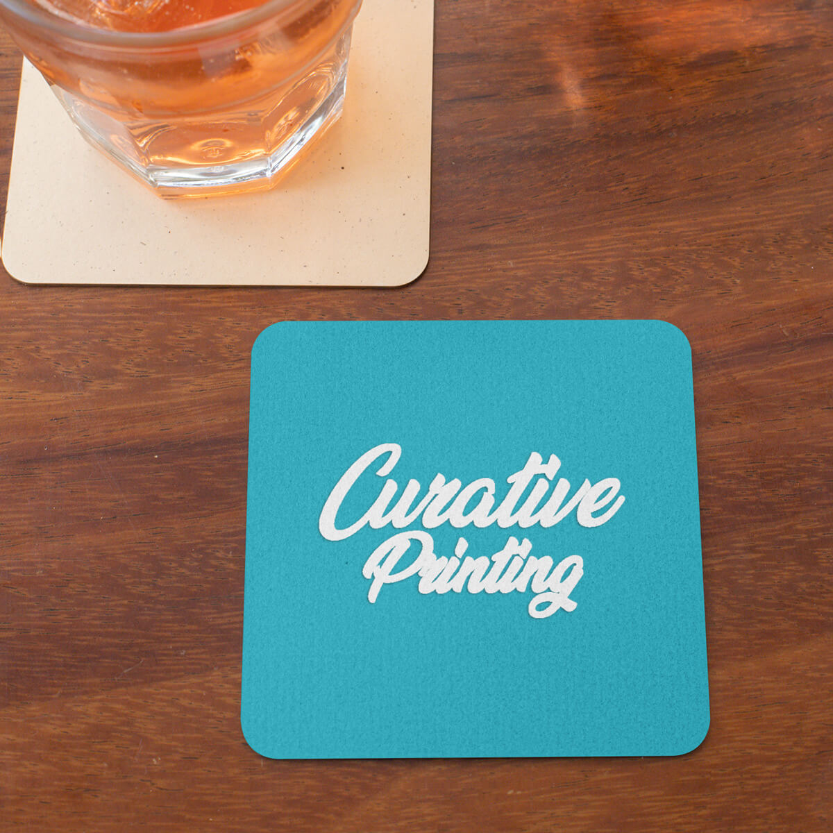 Table top with turquoise square coaster custom promotional drinkware by curative printing