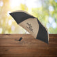 Black and tan auto open umbrella displayed with logo imprint by Curative Printing. 