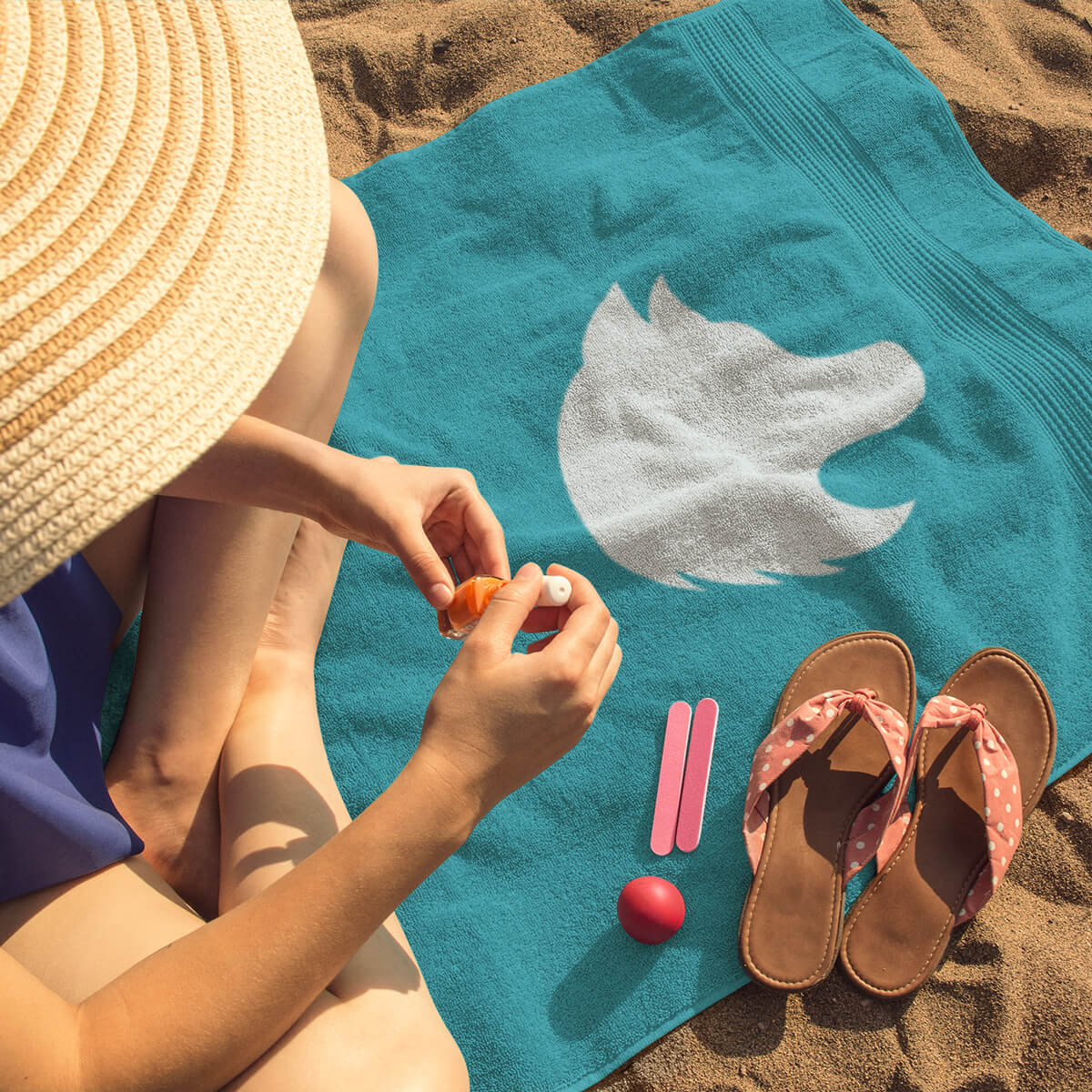 Woman doing her nails on a turquoise logo'd beach towel promotional towels by curative printing