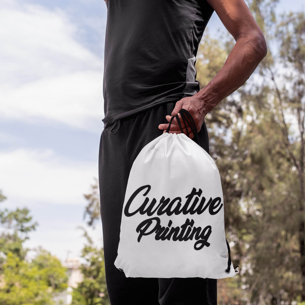 Man holding white custom promotional drawstring bags by curative printing