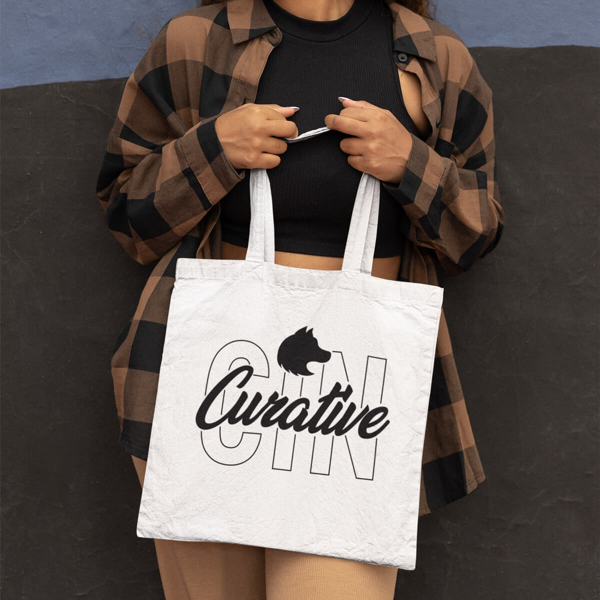 Woman holding white with black imprint custom promotional tote bags by curative printing