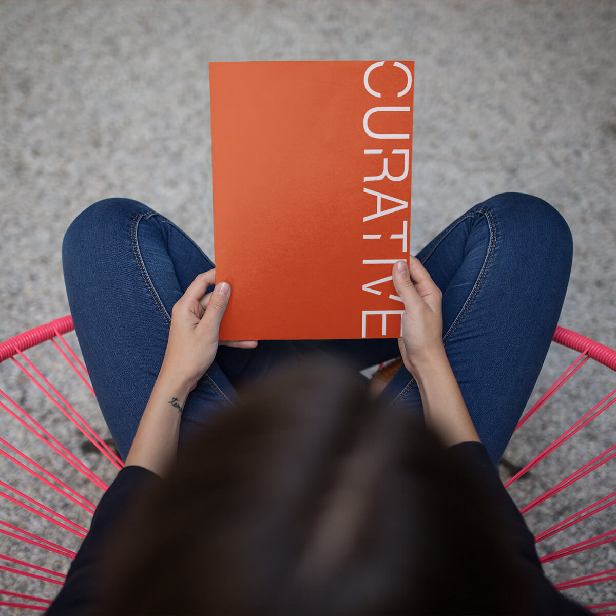 Woman sitting holding orange Curative imprint paper company pocket folder custom print by Curative Printing