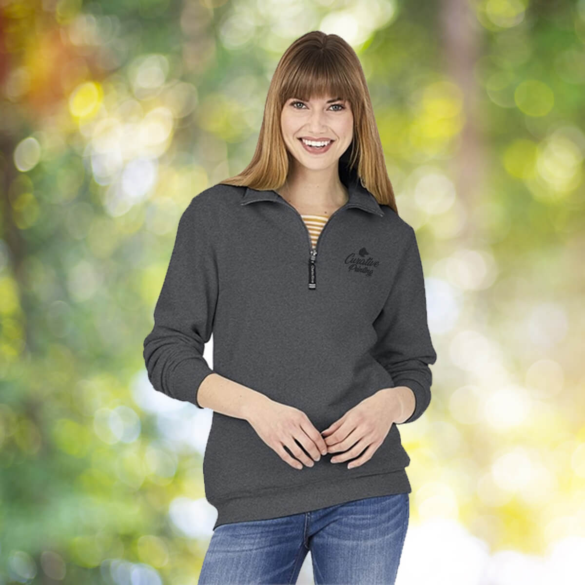 Woman in the outdoors wearing grey quarter zip sweatshirt apparel with black curative printing logo imprint